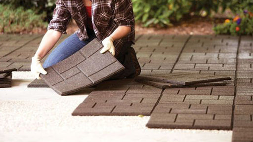 Installing brown rubber pavers on a patio