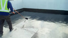 Bitumastic coating being rolled on a roof