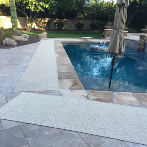 VInyl mesh pool mat laying on stone pool deck sandstone color