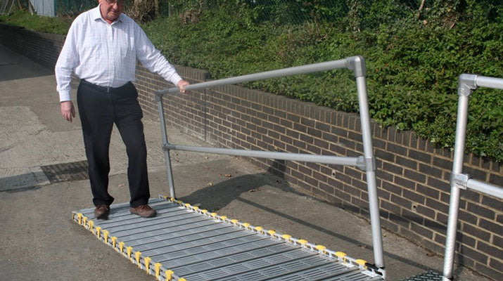 man walking on roll a ramp portable wheelchair ramp