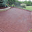 driveway with red rubber pavers installed by gate